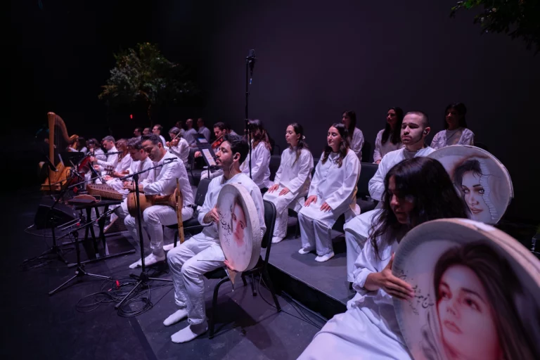 Zendeh Delan musicians in white playing daf and other Persian instruments on stage